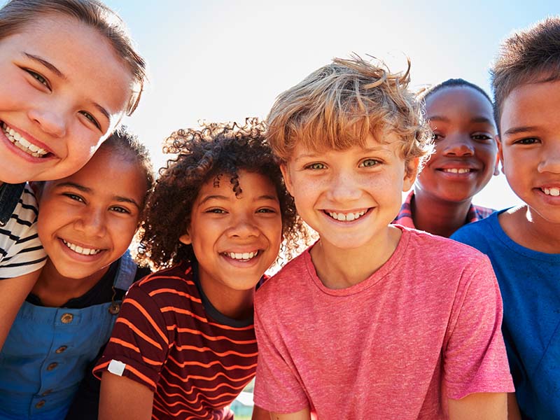 Group of preteen friends smiling together outdoors