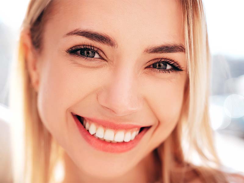 Close-up portrait of a blonde woman smiling
